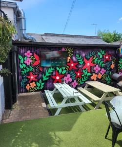 a wall with two picnic tables in front of a mural at The Albert Pub in Hitchin