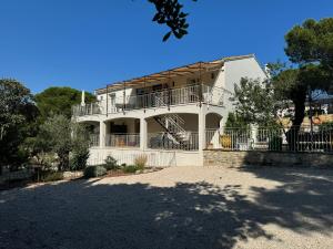 a white house with a balcony and a driveway at Dbarka7 in Sète