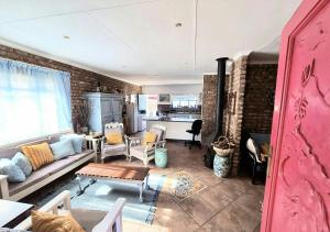 a living room with a couch and a table at Boknesstrand Self-catering Accommodation Holiday Home - a Mermaids Cottage minutes to the beach, lagoon, shops & more! in Boknes +41 photos