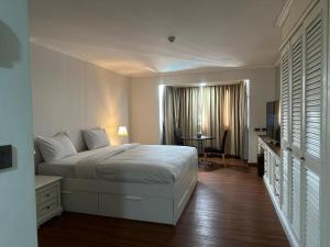 een slaapkamer met een bed, een bureau en een tafel bij Affordable Serviced Apartment Nana - Omni Tower Sukhumvit location in Bangkok +266 foto's