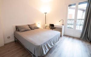 a bedroom with a bed and a desk and a window at Sant Ferriol in Olot