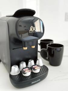 eine schwarze Kaffeemaschine mit Tassen auf der Theke in der Unterkunft Grand Central House - Master Penthouse Double Room Ensuite - GibraltarStay Apartments in Gibraltar + 17 Fotos