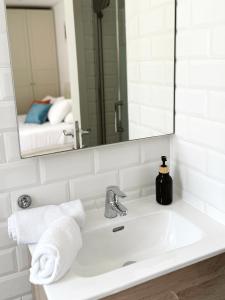 ein Waschbecken mit Spiegel und Handtuch in der Unterkunft Grand Central House - Master Penthouse Double Room Ensuite - GibraltarStay Apartments in Gibraltar