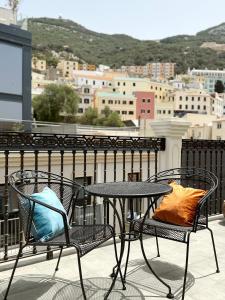 2 Stühle und ein Tisch mit Kissen auf dem Balkon in der Unterkunft Grand Central House - Master Penthouse Double Room Ensuite - GibraltarStay Apartments in Gibraltar