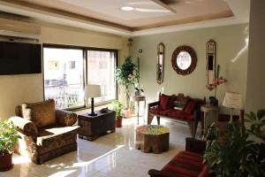 a living room with couches and a tv and a couch at New Rafi Hotel in Amman