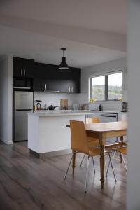 une cuisine avec une table et des chaises dans une pièce dans l'établissement Merino Cottage Meadowbank Lake, à Ellendale 63 autres photos