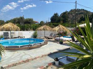 a swimming pool in a yard with chairs at EnjoyRhodes Villa near Faliraki in Kalithies