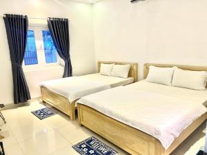 deux lits dans une chambre avec une fenêtre dans l'établissement Star Hotel - Khách sạn giá bình dân, à Vung Tau 17 autres photos