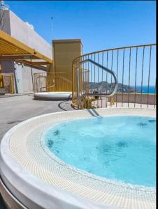 een hot tub op een patio met de oceaan op de achtergrond bij Intempo 31 panoramic sunrise & spa in Benidorm
