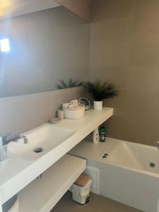 een witte badkamer met een wastafel en een bad bij Intempo 31 panoramic sunrise & spa in Benidorm