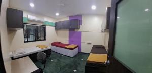 a room with two beds and a table and chairs at JOY HOSTEL - Digital Nomads Hostel & PG - Koregaon Park in Pune