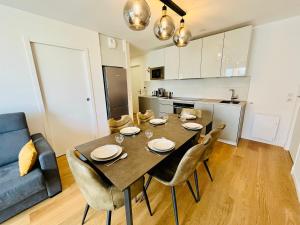 a kitchen and dining room with a table and chairs at Elégance & Confort, Proche place Morny, 3 Pièces, 2 Sdb, 2 WC, Balcon, Parking, Wifi ultra haut-débit, tout à pied in Deauville