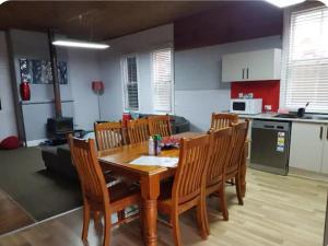 a kitchen and dining room with a wooden table and chairs at 4 Bedroom Federation Cottage in Lithgow
