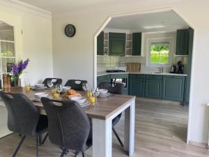 a kitchen with a wooden table with chairs around it at het Veluws paradijs, nu met extra bij te boeken Hottub in Voorthuizen
