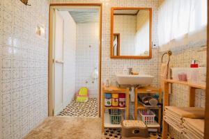 ein kleines Badezimmer mit Waschbecken und Spiegel in der Unterkunft 香川県高松市中心部で駐車6台無料の家族向けゲストハウス in Takamatsu + 16 Fotos