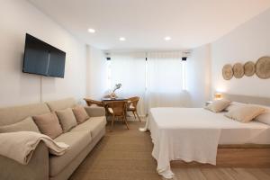a living room with two beds and a couch at Aparthotel Centric in Castelldefels