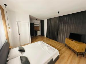 a bedroom with a large bed and a television at Nature Nook in Eşelniţa