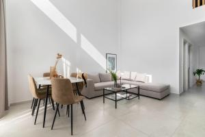a living room with a table and a couch at Calliope luxury loft with backyard in Ierapetra