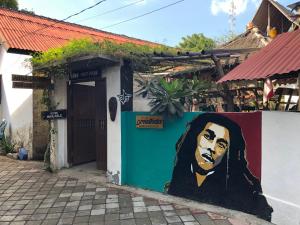 Un edificio con una pintura de la cara de un presidente. en fullesguesthouse, en Gili Trawangan