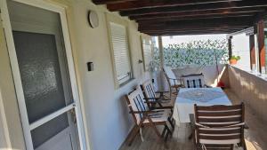 a porch with a table and chairs on a balcony at Sea Side View in Dhíkella