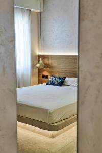 a bedroom with a bed with a mirror at Ios Resort in Ios Chora