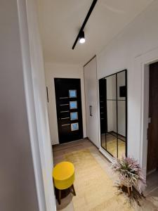 a room with a yellow stool and a mirror at Apartments Pepdjonovic in Ulcinj