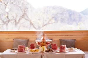 una mesa cubierta con platos de comida y un tazón de comida en Great wall adventure park, en Jiuduhe 44 fotos más
