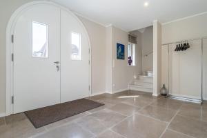 un corridoio bianco con porta e pavimento piastrellato di Einzelhaus Huus Elphi Huus Elphi a Tating Altre 23 foto