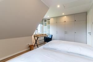 una camera con letto bianco e scrivania di Einzelhaus Huus Elphi Huus Elphi a Tating