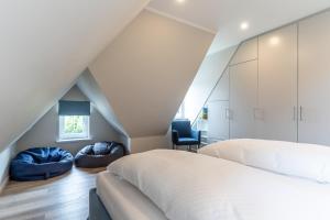 una camera mansardata con letto e sedia di Einzelhaus Huus Elphi Huus Elphi a Tating