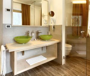 a bathroom with two green sinks and a shower at Color Home Suite Apartments in Predazzo