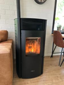 a fireplace in a living room next to a couch at Vakantiehuis Lanaken in Lanaken