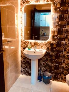 a bathroom with a sink and a mirror at قريه اكوا فيو الساحل الشمالى in El Alamein
