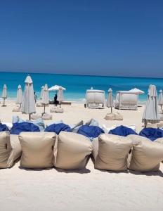 a group of pillows on a beach with the ocean at قريه اكوا فيو الساحل الشمالى in El Alamein