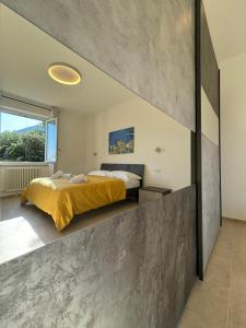 a bedroom with a bed and a concrete wall at Ca' dii Bürsa 2 - HOMY 5 TERRE in Volastra