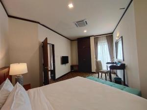 a hotel room with a bed and a desk at Riviera Suites Melaka in Melaka