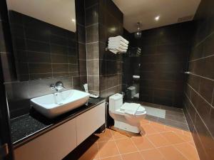 a bathroom with a sink and a toilet at Riviera Suites Melaka in Melaka