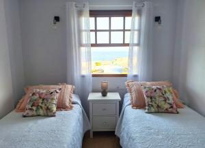 deux lits dans une chambre avec une fenêtre dans l'établissement Pem House, apartamento con vistas al mar, à Santa Cruz de la Palma