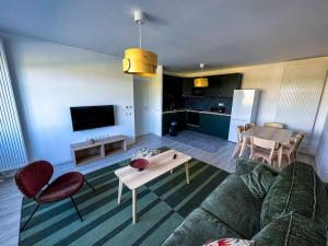 a living room with a couch and a table at Somptueux près de Disneyland in Chessy