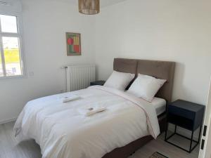 a bedroom with a large bed with white sheets and pillows at Somptueux près de Disneyland in Chessy