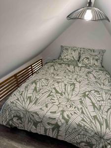 a bedroom with a bed with a comforter and a lamp at Maison en plein coeur de la cité médiévale de Moret-sur-Loing avec jardin ! in Moret-sur-Loing