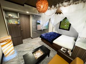 a bedroom with a bed and a fireplace and a chandelier at Hotel BaliBali 鶯谷 in Tokyo