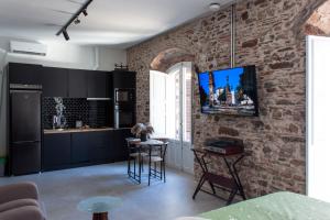 a kitchen with black cabinets and a brick wall at Suites Plaza Alta in Algeciras
