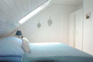 une chambre avec un grand lit avec une grande lucarne dans l'établissement Ferienhaus Möwe, à Ditzum 5 autres photos