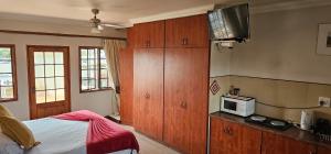 1 dormitorio con 1 cama y TV en la barra en Villa Sant Andrea, en Johannesburgo