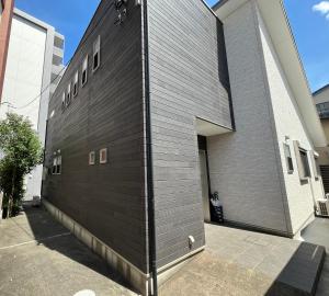 a building with a black brick wall at U&T House in Beppu