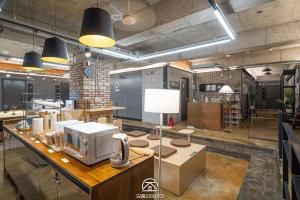 a large room with a microwave on a table at Travel Light Hostel in Busan