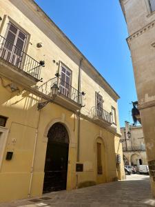a yellow building with two balconies and a door at Casa Leoci in Lecce