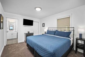 a bedroom with a blue bed and a television at Glimmering Sands in Depoe Bay
