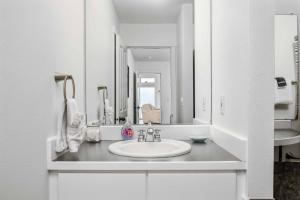 a white bathroom with a sink and a mirror at Glimmering Sands in Depoe Bay +27 photos